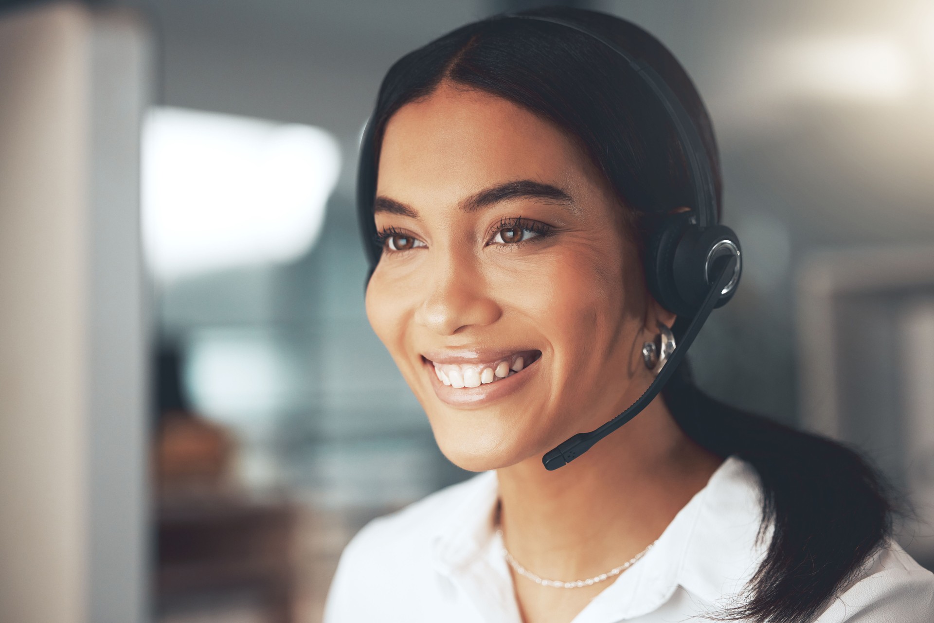 Shot of a young call centre agent sitting alone in her office and using her computer
